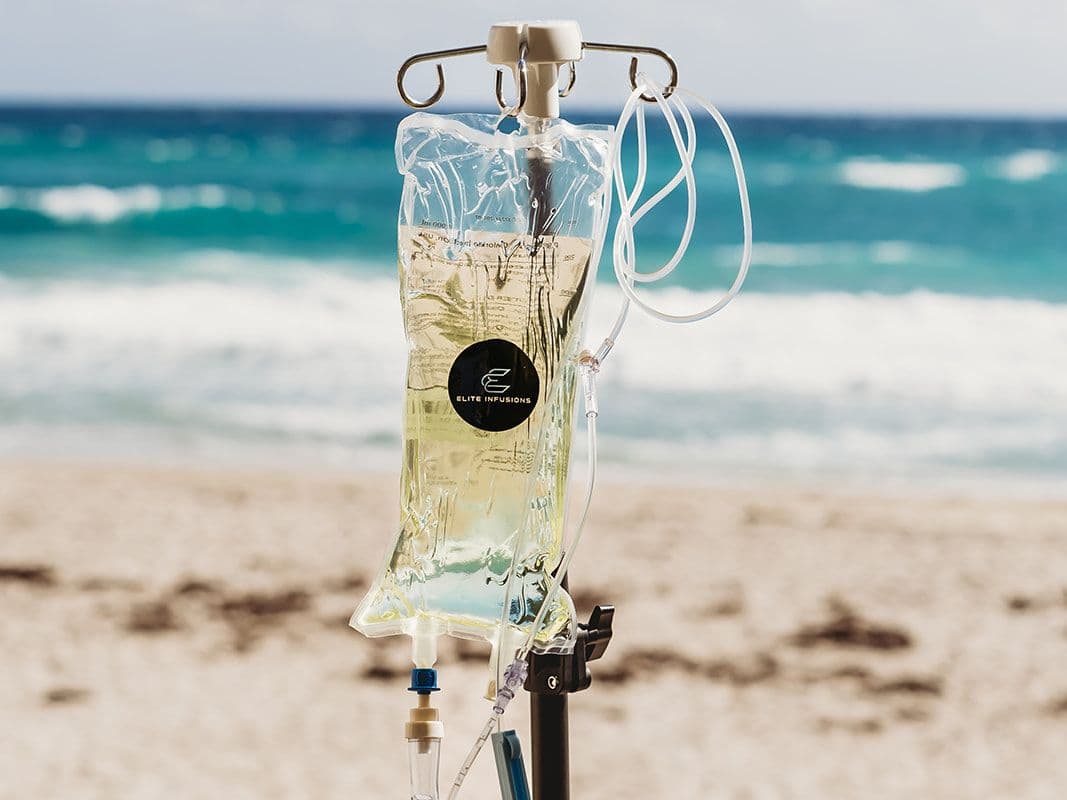 An IV bag on a stand facing the ocean