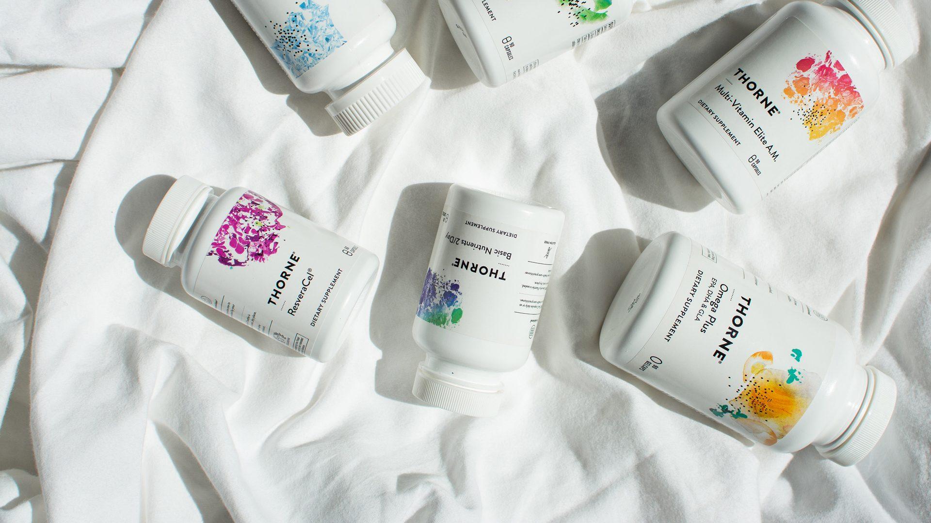 Thorne supplement bottles laid out on white linen in sunlight